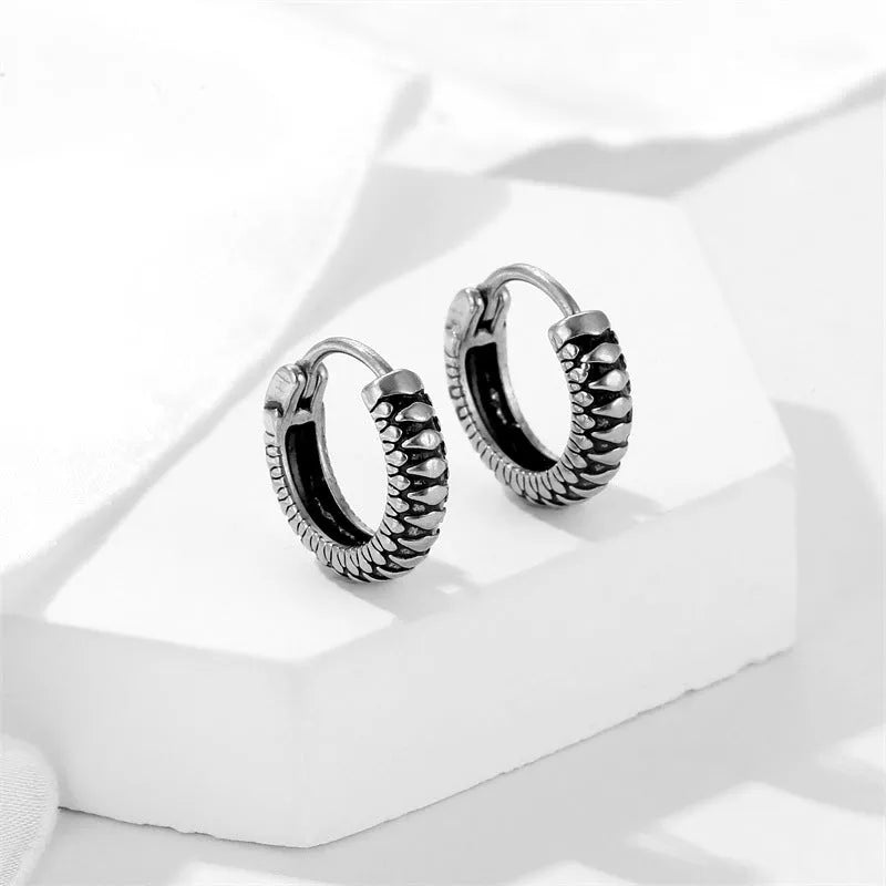 Silver geometric striped earrings with a circular centre, made from polished stainless steel.