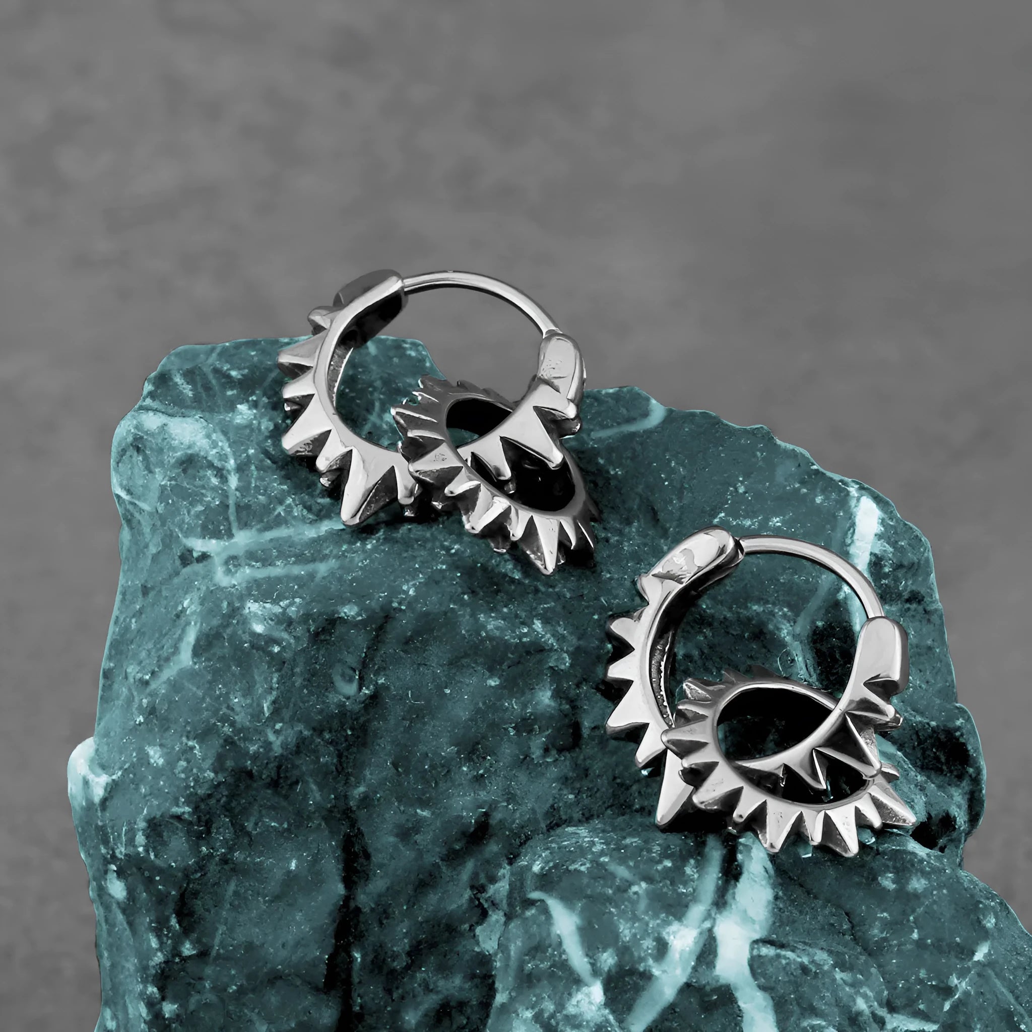 Stainless steel retro round ring earrings with polished steel finish on model