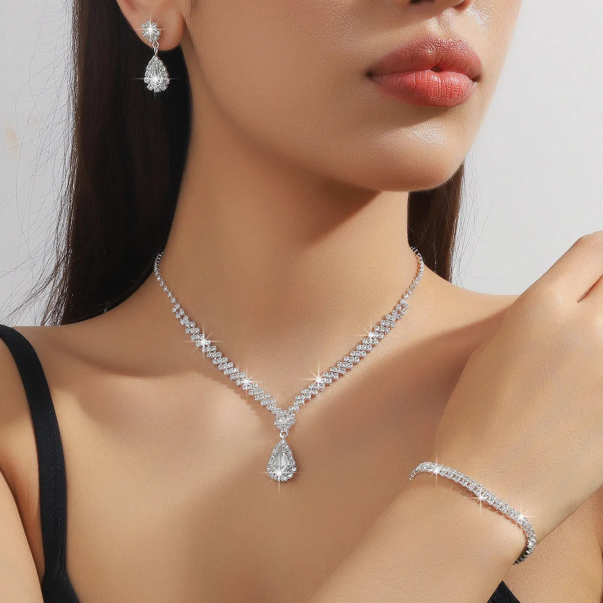 Claw chain rhinestone jewellery set with water drop shapes in a choice of colours, showing necklace, earrings, and optional bracelet.