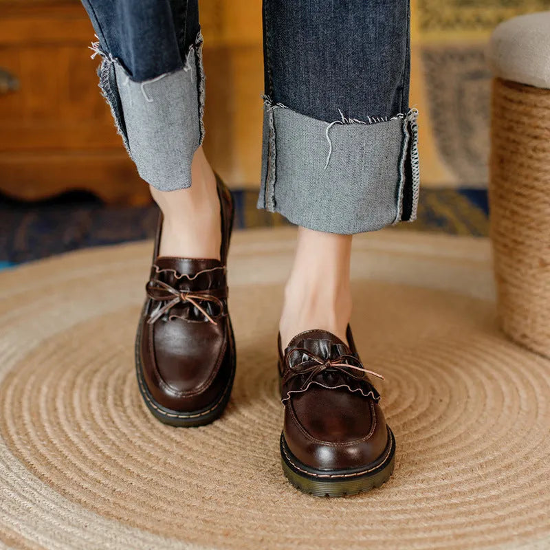 Women's black leather shoes with round toe and chunky flat heel, low-top design.