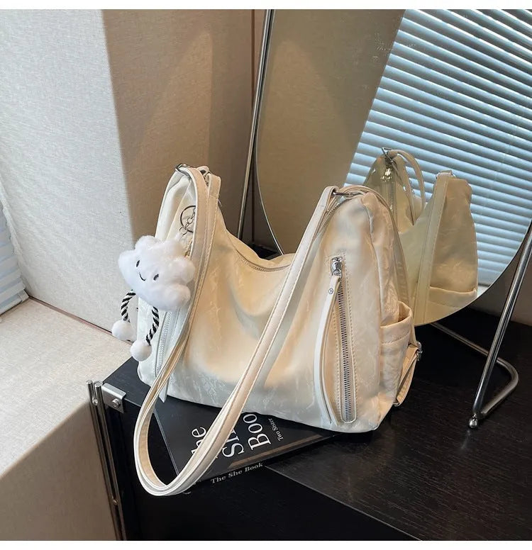 Women's soft PU fashion backpack with pendant accessory in beige, black, blue, and silver colour options