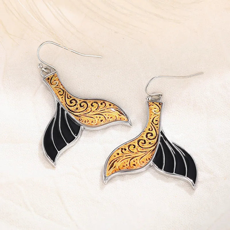 Women's retro-style fishtail-shaped alloy earrings with a whale decoration in white gold colour.
