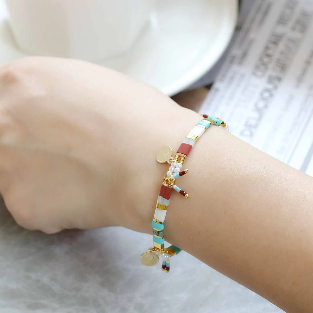 Women's handcrafted imitation pearl bracelet shown in one of six available colour variations.