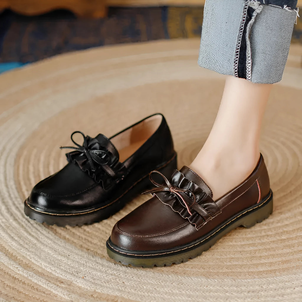 Women's black leather shoes with round toe and chunky flat heel, low-top design.