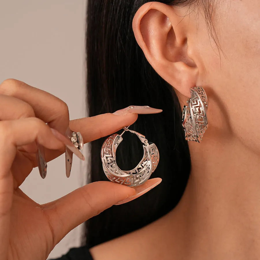 Women's geometric hollow stud earrings with exaggerated twisted round shape and electroplated silver finish