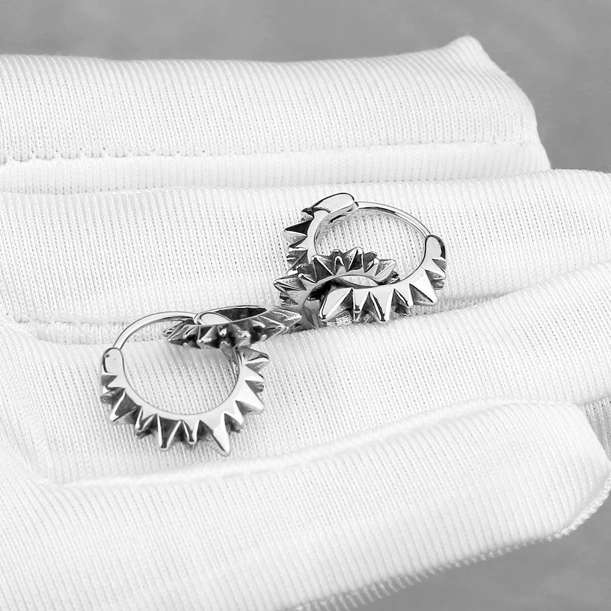 Stainless steel retro round ring earrings with polished steel finish on model