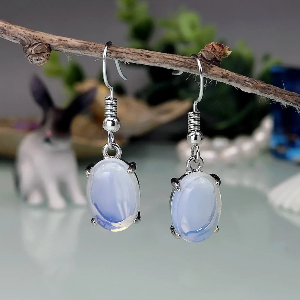 Women's opal earrings with drop shape design in moonlight white colour featuring cross element