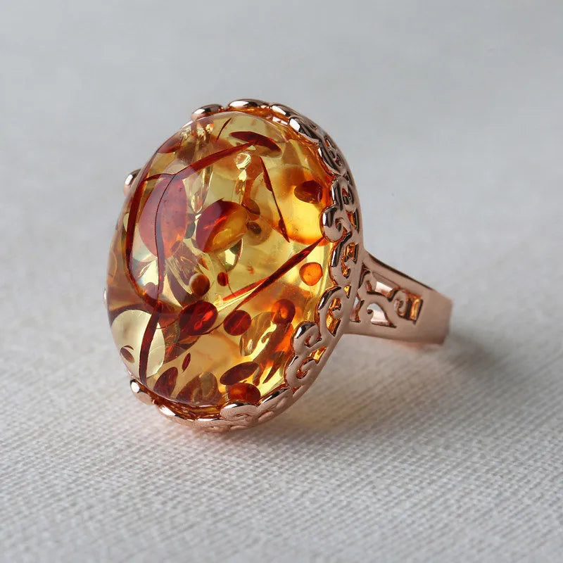 Close-up of a natural amber stone set in a gold-coloured ethnic-style ring band.