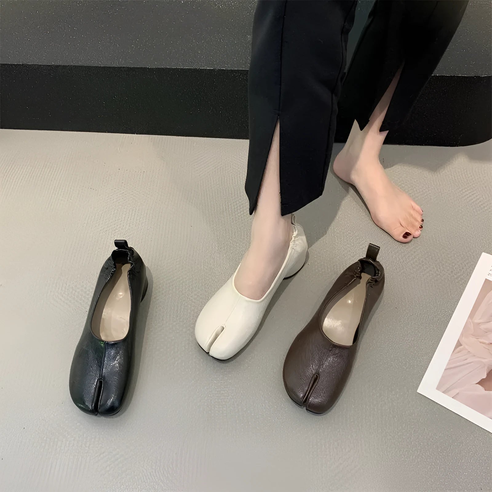 Women's black split toe chunky heel pumps with round head and rubber sole on a white background.