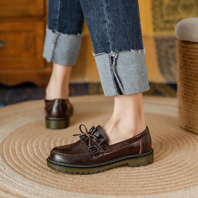 Women's black leather shoes with round toe and chunky flat heel, low-top design.