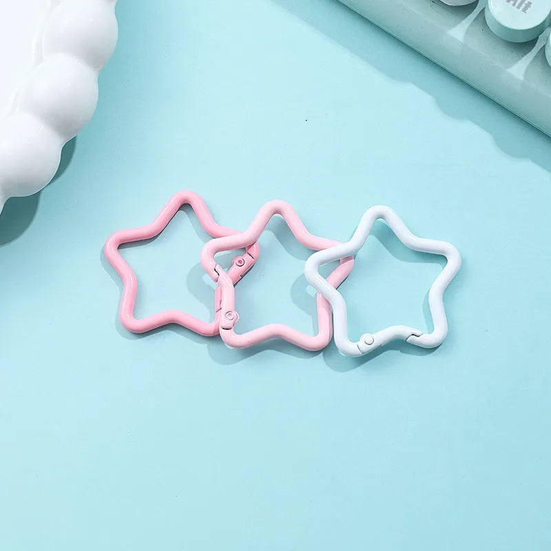 Zinc alloy five-pointed star keychain charm in assorted colours on a key ring.
