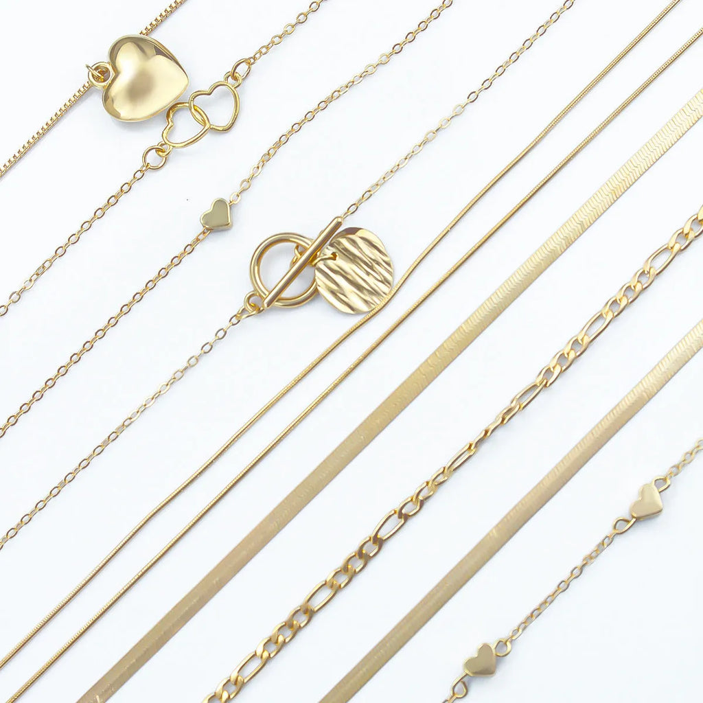 10 gold necklaces with snake bone chains and alloy pendants arranged in jewellery set