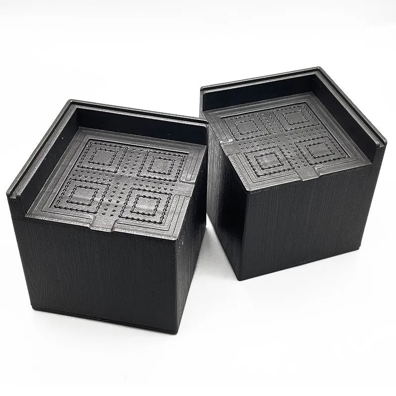 Four black plastic bed foot risers for furniture height adjustment