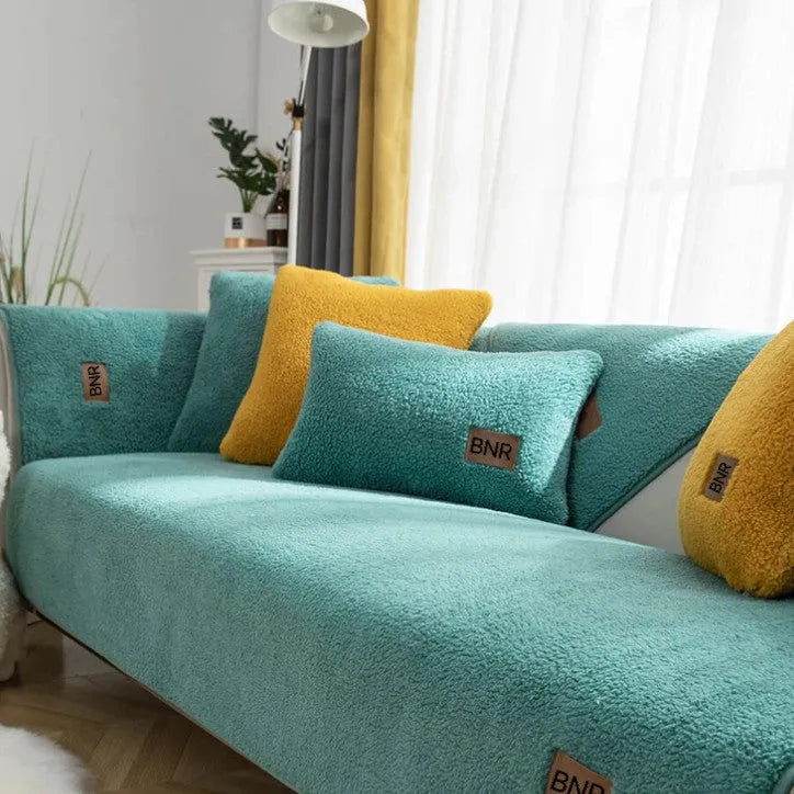 Lambswool sofa slipcover in a solid blue colour, shown on a sofa.