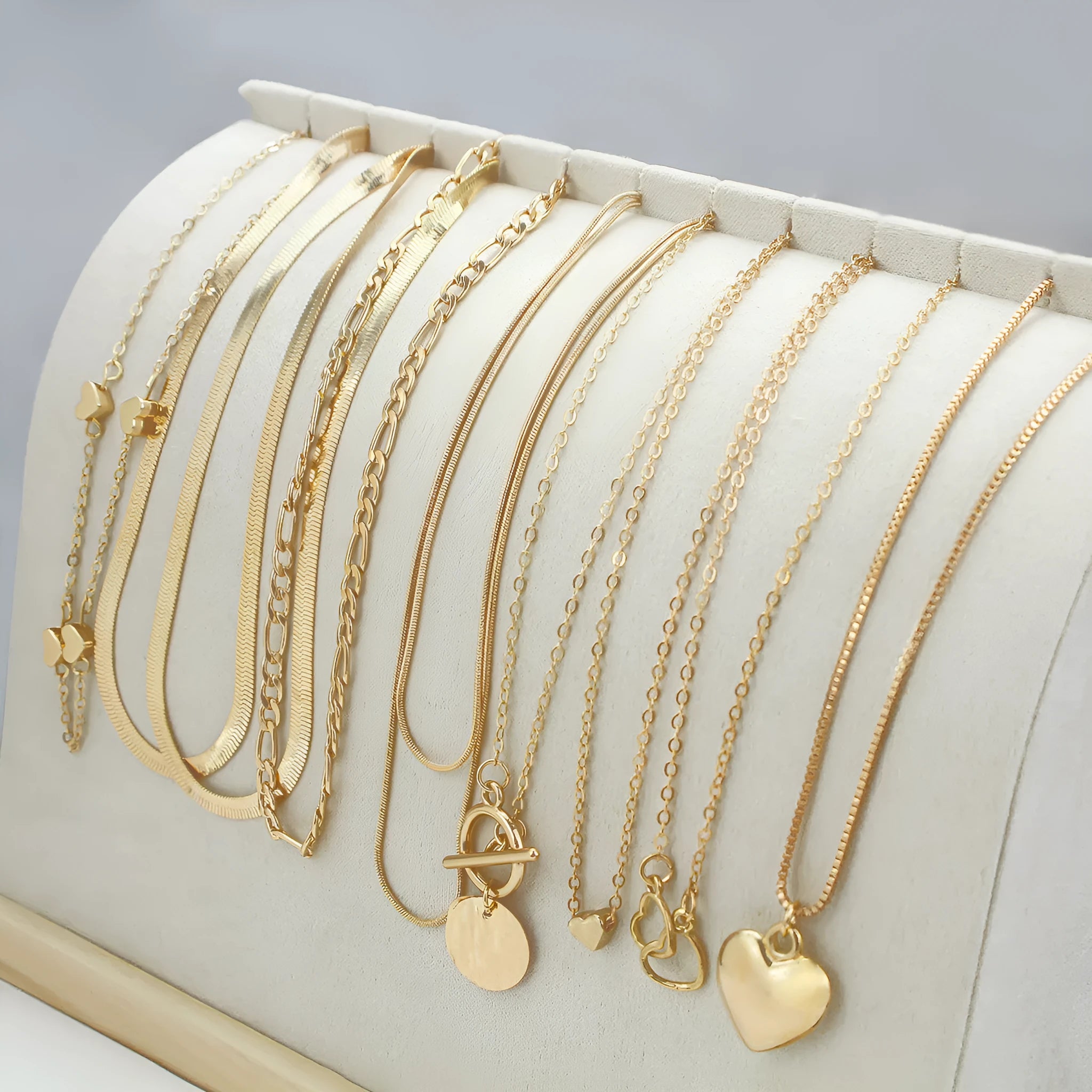 10 gold necklaces with snake bone chains and alloy pendants arranged in jewellery set