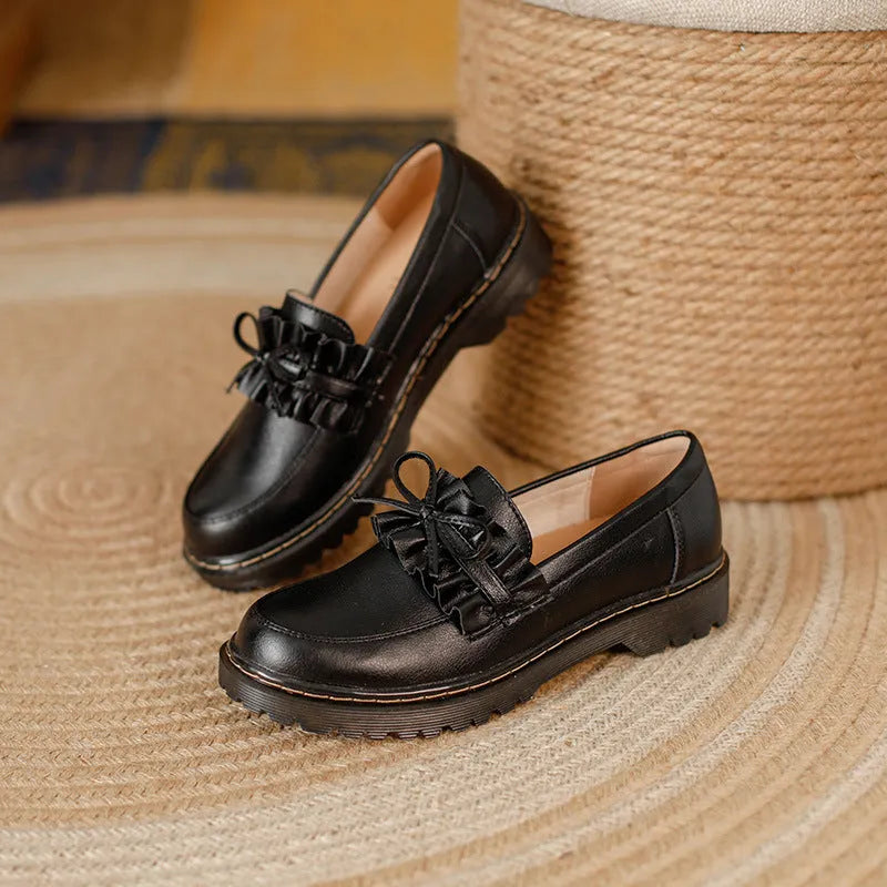 Women's black leather shoes with round toe and chunky flat heel, low-top design.