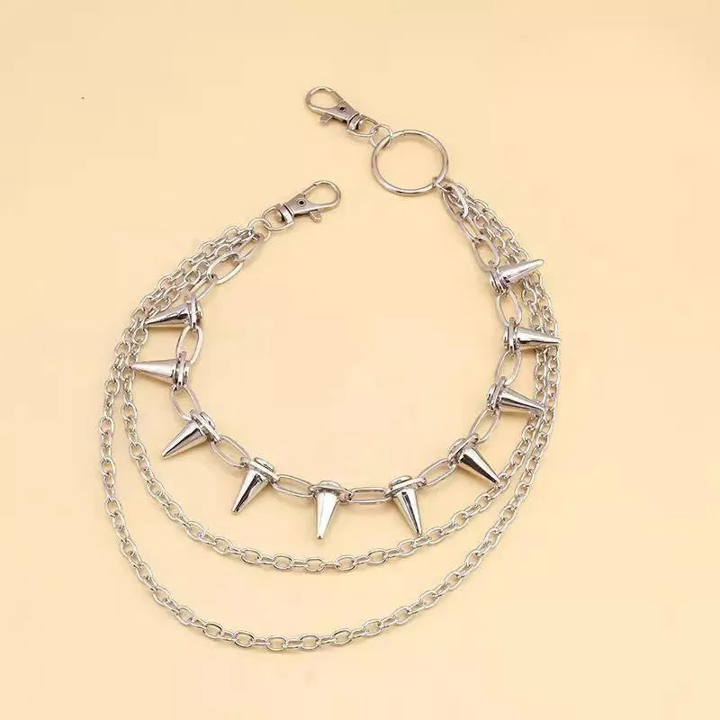 Silver double-layer pant chain with rivet accents and zipper details on dark trousers