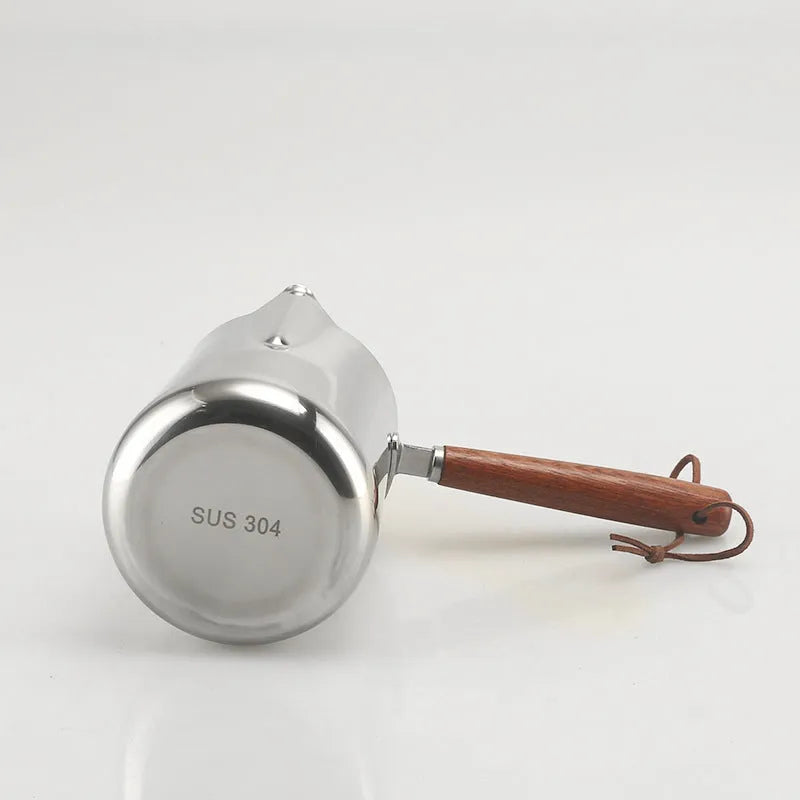 Stainless steel coffee cup with wooden handle showing measurement scale marks