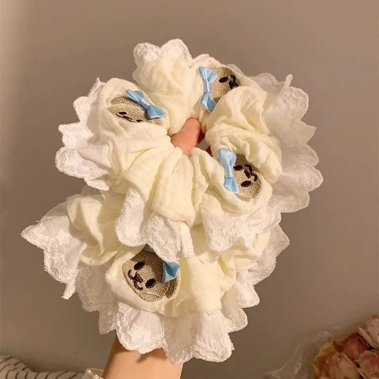 Close-up of a blue cloth hair ring with a bear design and a bowknot.