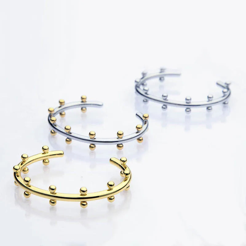 Stainless steel C-shaped bean bead with textured rivet surface in gold colour