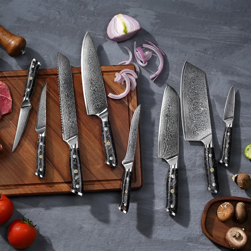 Damascus steel kitchen knife set with eight blades including Japanese and boning knives on a wooden surface