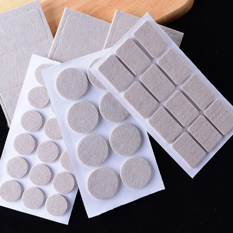Assorted beige plastic chair leg stoppers in round and square shapes on a wooden floor.