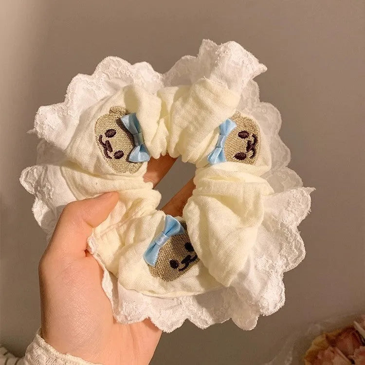Close-up of a blue cloth hair ring with a bear design and a bowknot.