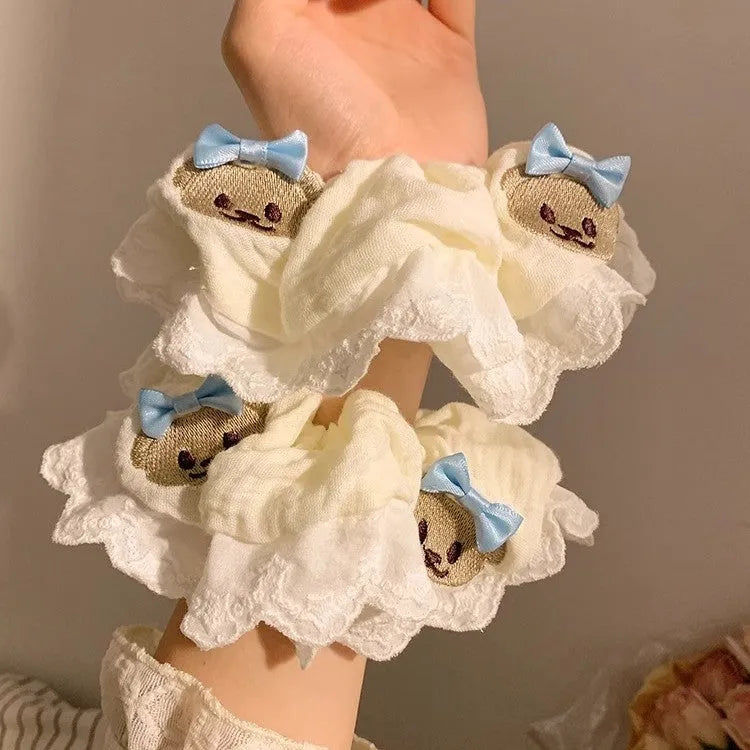 Close-up of a blue cloth hair ring with a bear design and a bowknot.