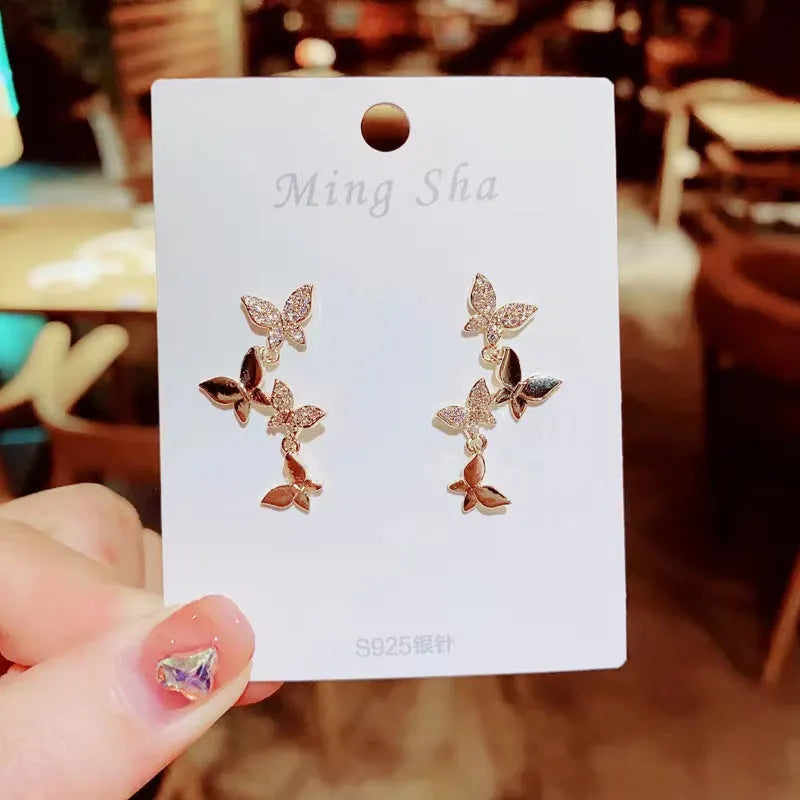 Gold colour copper butterfly drop earrings with four butterfly design elements
