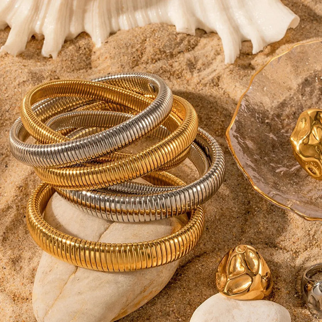 Women's titanium steel elastic bracelet showing vertical stripe ring pattern in gold finish