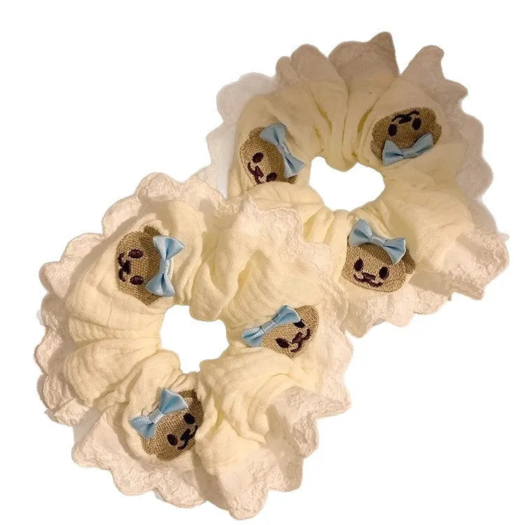 Close-up of a blue cloth hair ring with a bear design and a bowknot.