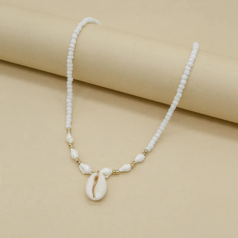 White shell bead necklace with conch pendant and mother-of-pearl detail
