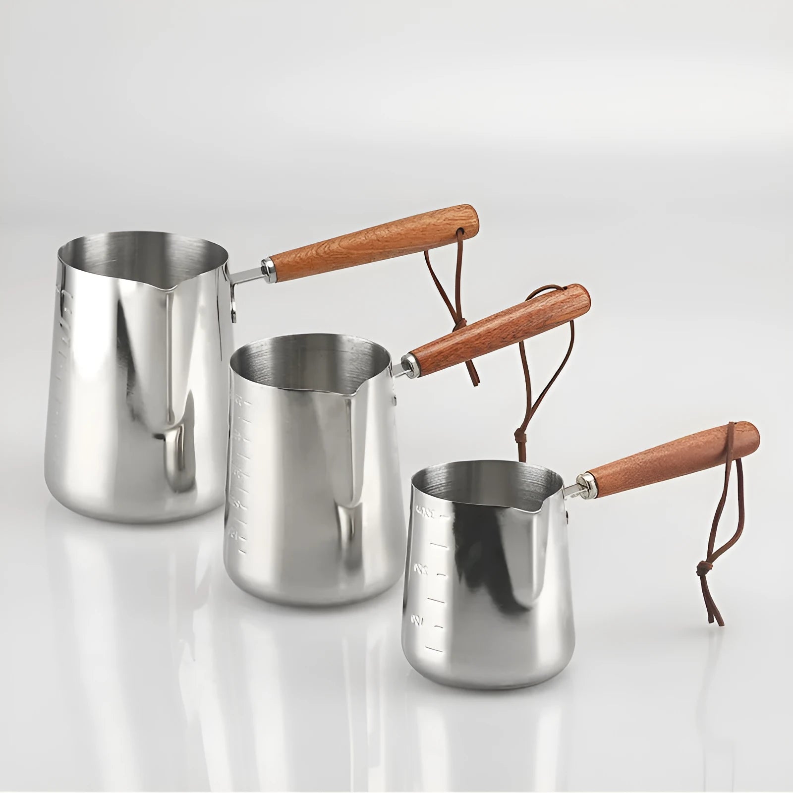 Stainless steel coffee cup with wooden handle showing measurement scale marks