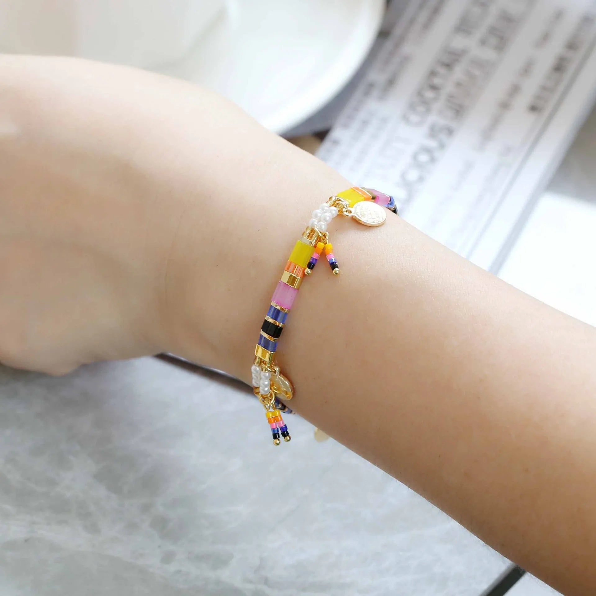 Women's handcrafted imitation pearl bracelet shown in one of six available colour variations.
