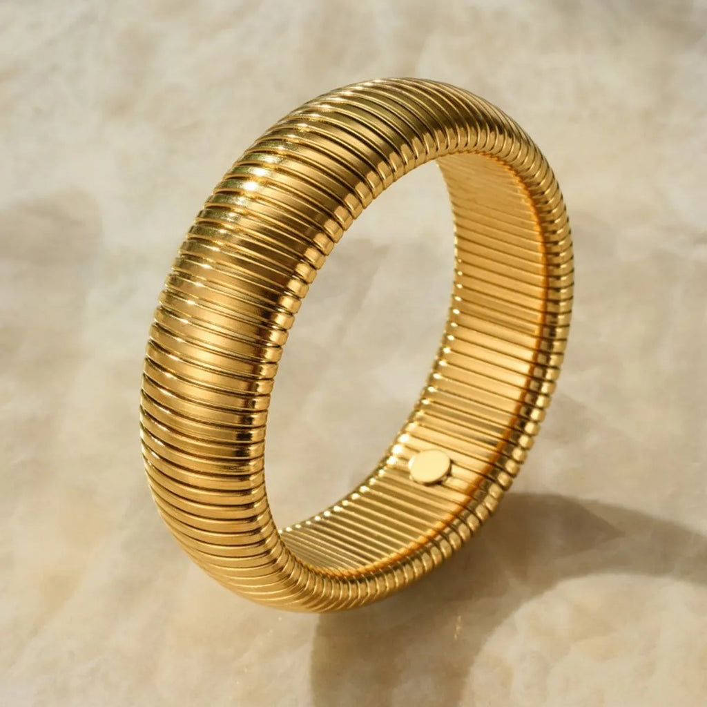 Women's titanium steel elastic bracelet showing vertical stripe ring pattern in gold finish