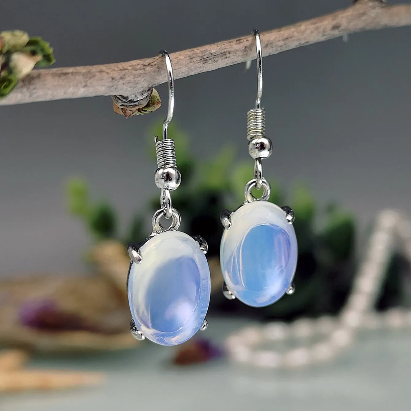 Women's opal earrings with drop shape design in moonlight white colour featuring cross element