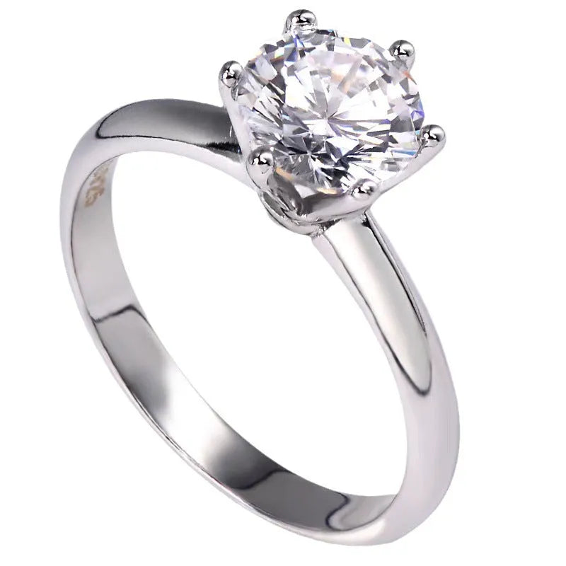 White gold plated geometric ring with a six-claw setting holding a zircon stone.