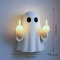 Small white ghost-shaped plastic night lamp for Halloween decoration on a table.