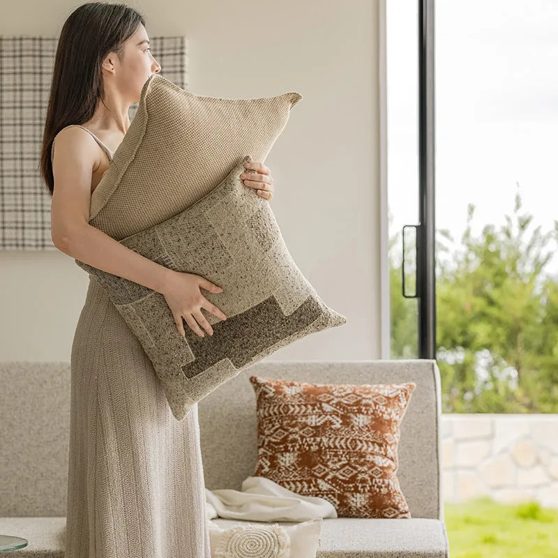 Solid colour decorative cushion on a grey sofa, showing red coffee brown and plain colour options.
