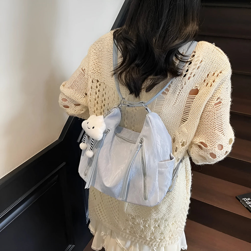 Women's soft PU fashion backpack with pendant accessory in beige, black, blue, and silver colour options