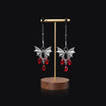 Silver alloy bat-shaped nipple clamp with ruby details and adjustable rubber-padded mechanism.