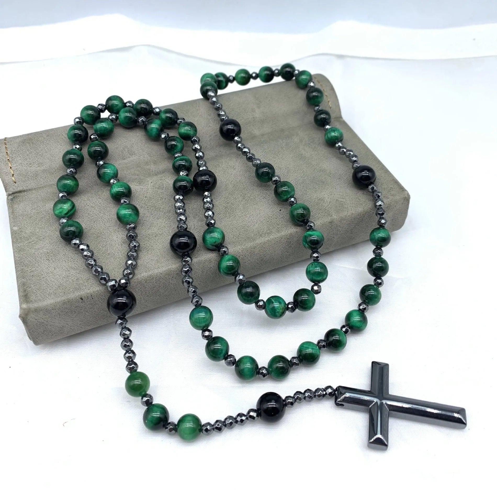 Men's stone necklace with a geometric cross pendant on a ball bead chain, showing the safety lock clasp.
