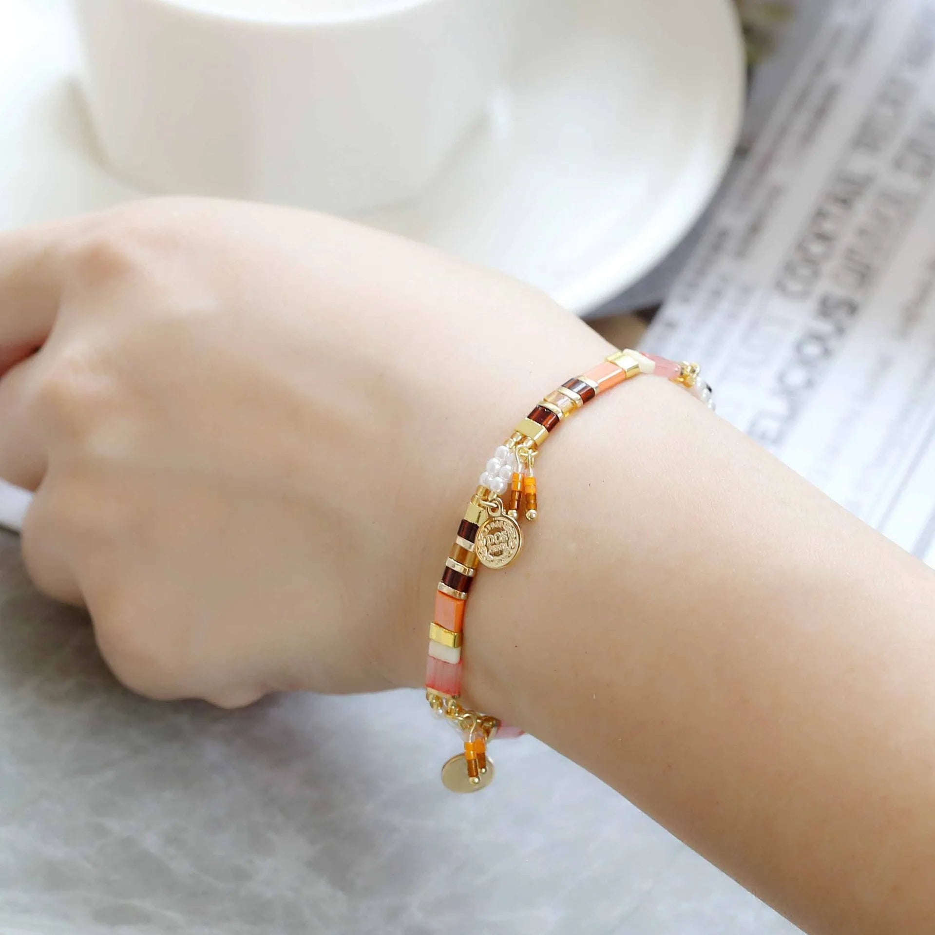 Women's handcrafted imitation pearl bracelet shown in one of six available colour variations.