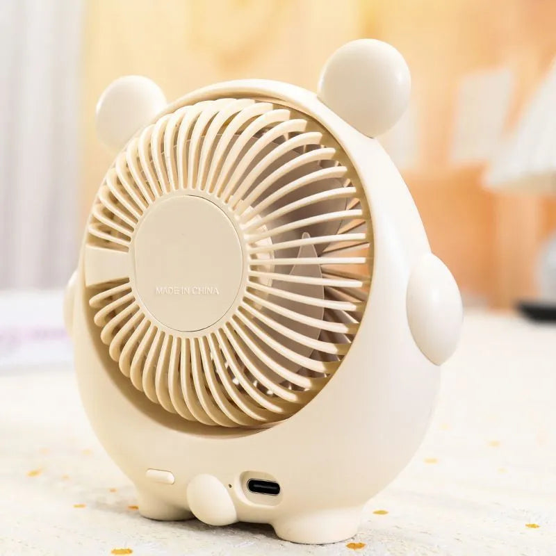 Dog-themed plastic USB desktop fan in Apricot Puppy colour on a wooden desk.