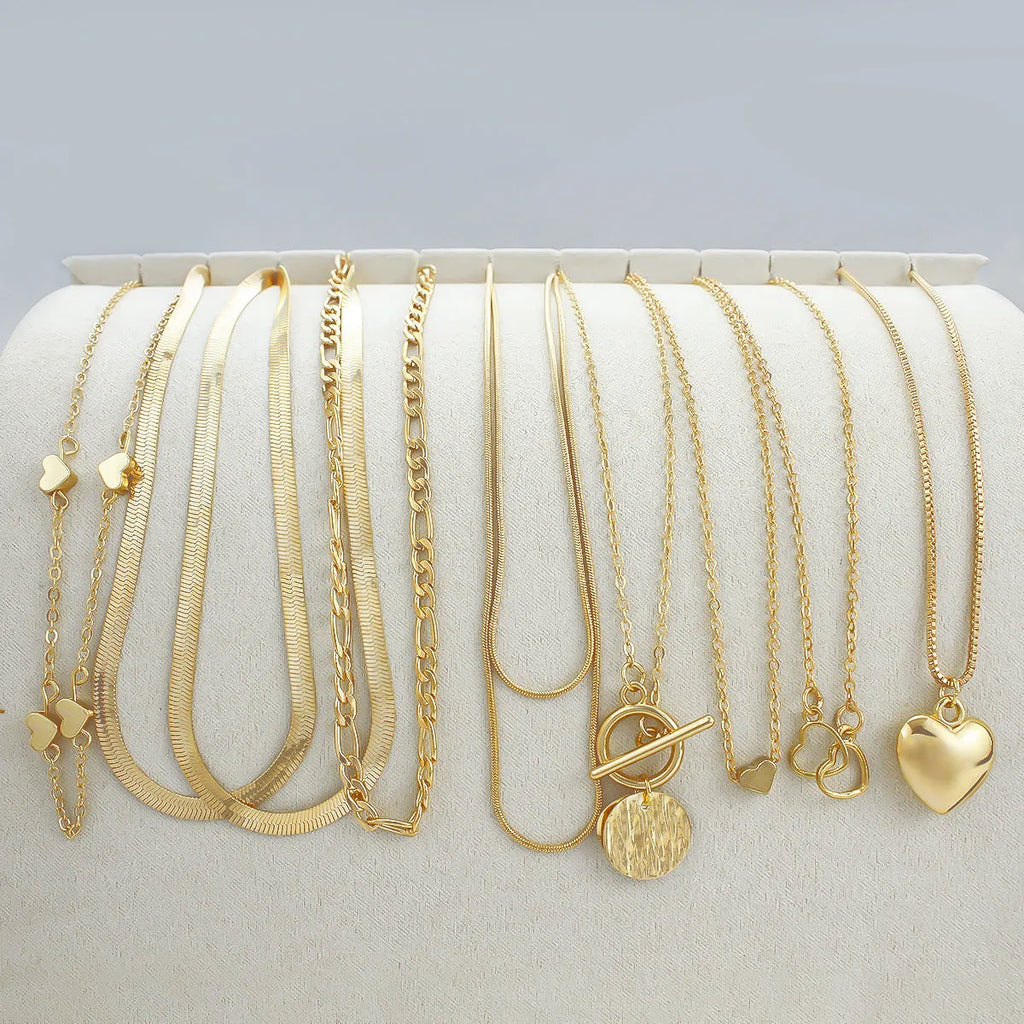 10 gold necklaces with snake bone chains and alloy pendants arranged in jewellery set