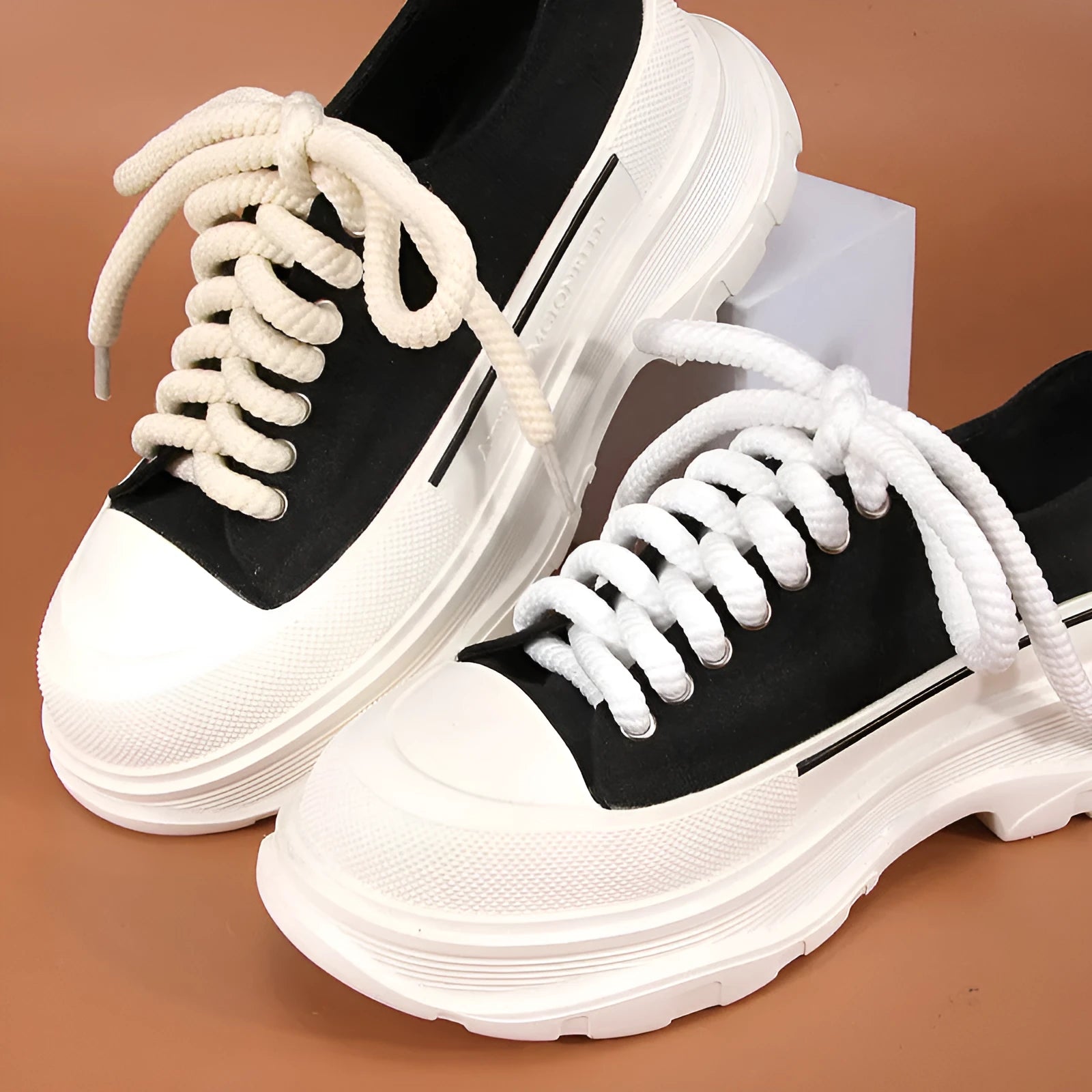 Round white woven shoelace on a grey background showing its 10mm diameter and textured weave.