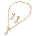 Gold baroque pearl pendant necklace and ear stud set for women on a white background.