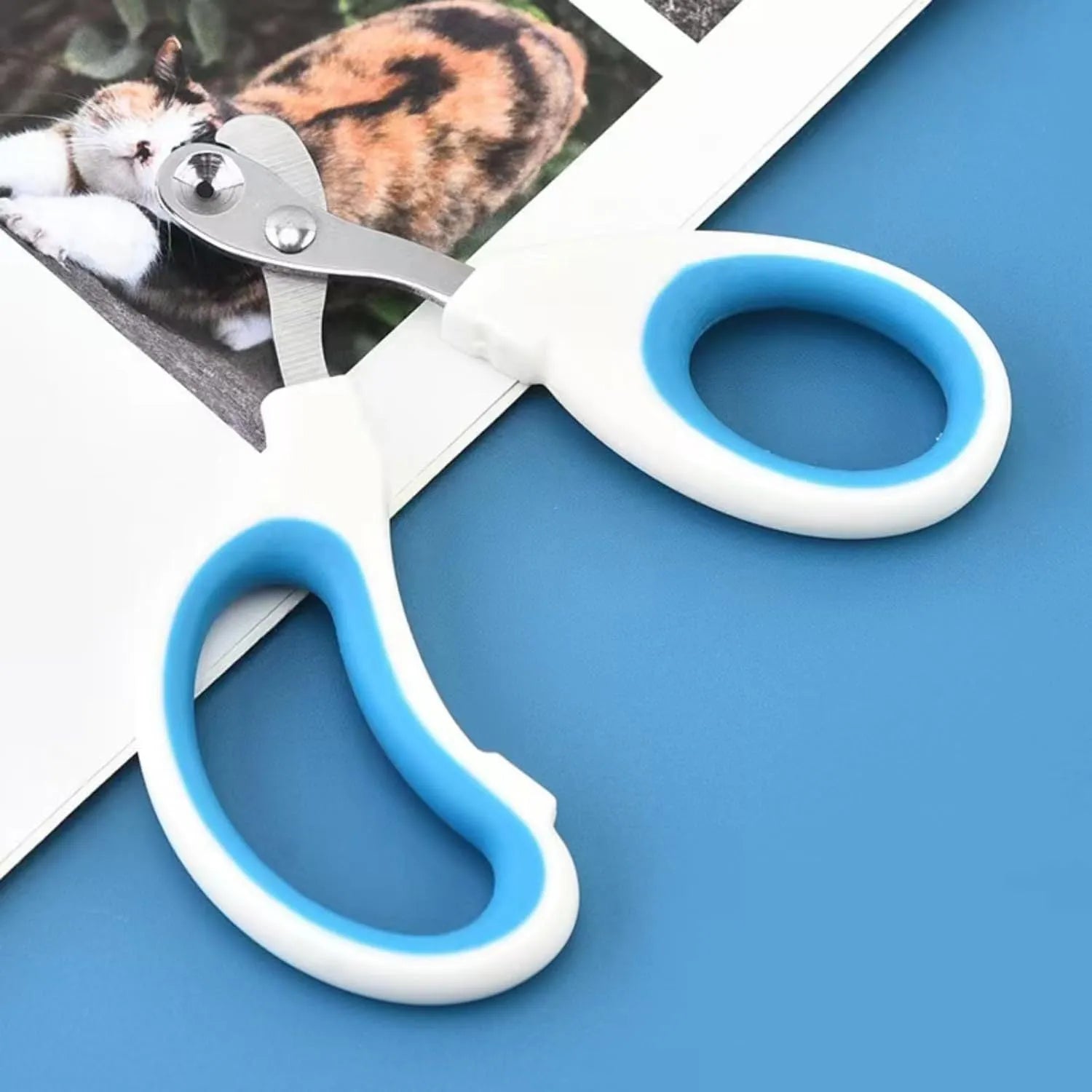 Blue cat nail clippers with circular cut hole and cushioned handle for safe pet nail trimming