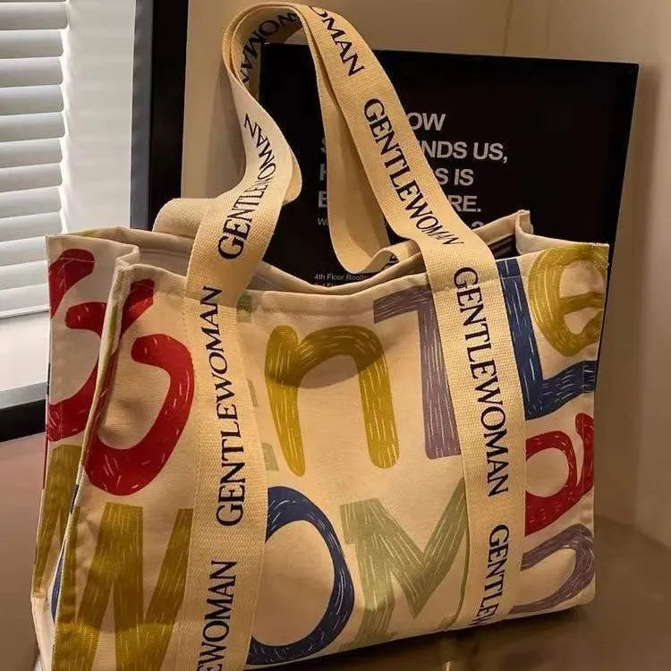 Canvas tote bag with printed design options including black letters, coloured letters, and pattern styles
