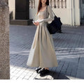 Women's black square collar knitted A-line dress with long sleeves and an elasticated waist.